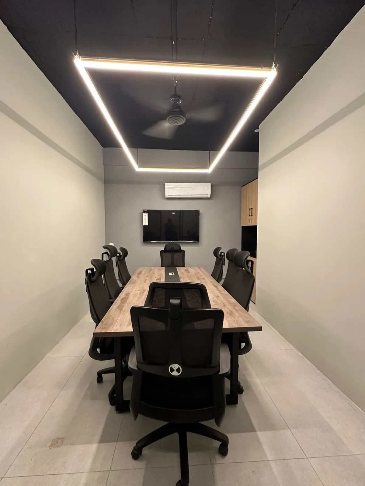 A meeting room with a long table and a statement light frame at RSpace 59th Street