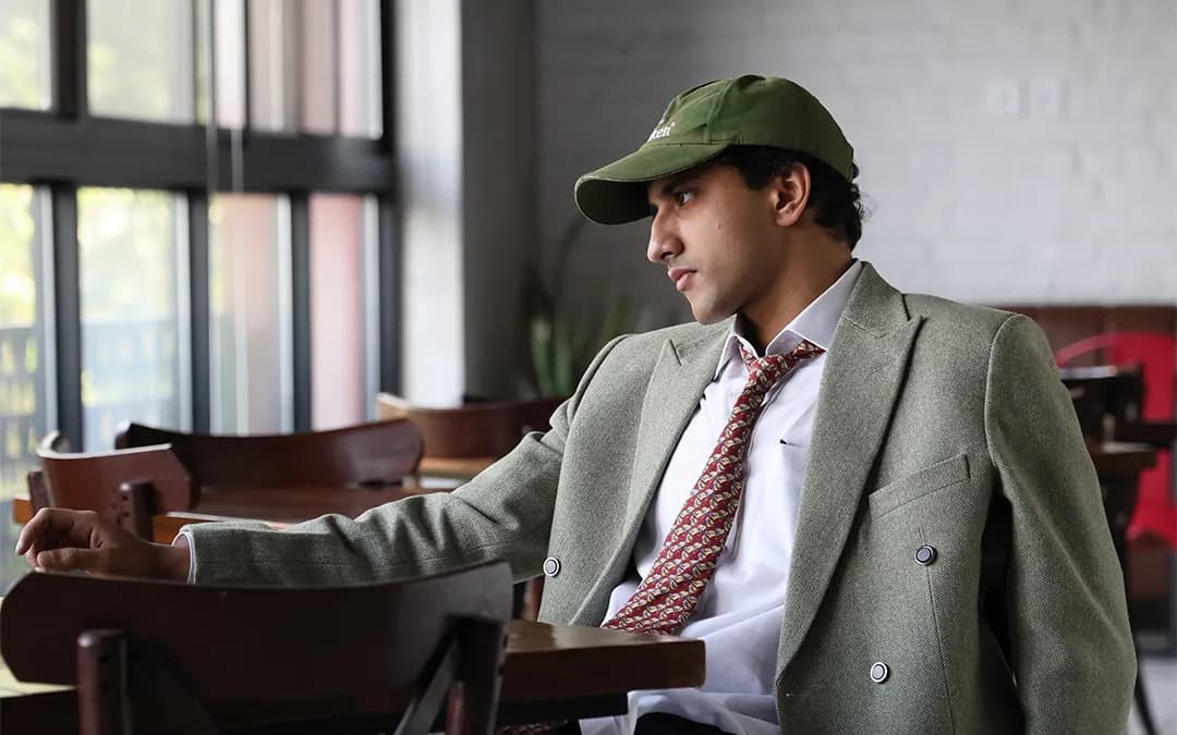 A member in a tweed jacket seated by the windows in the RSpace café