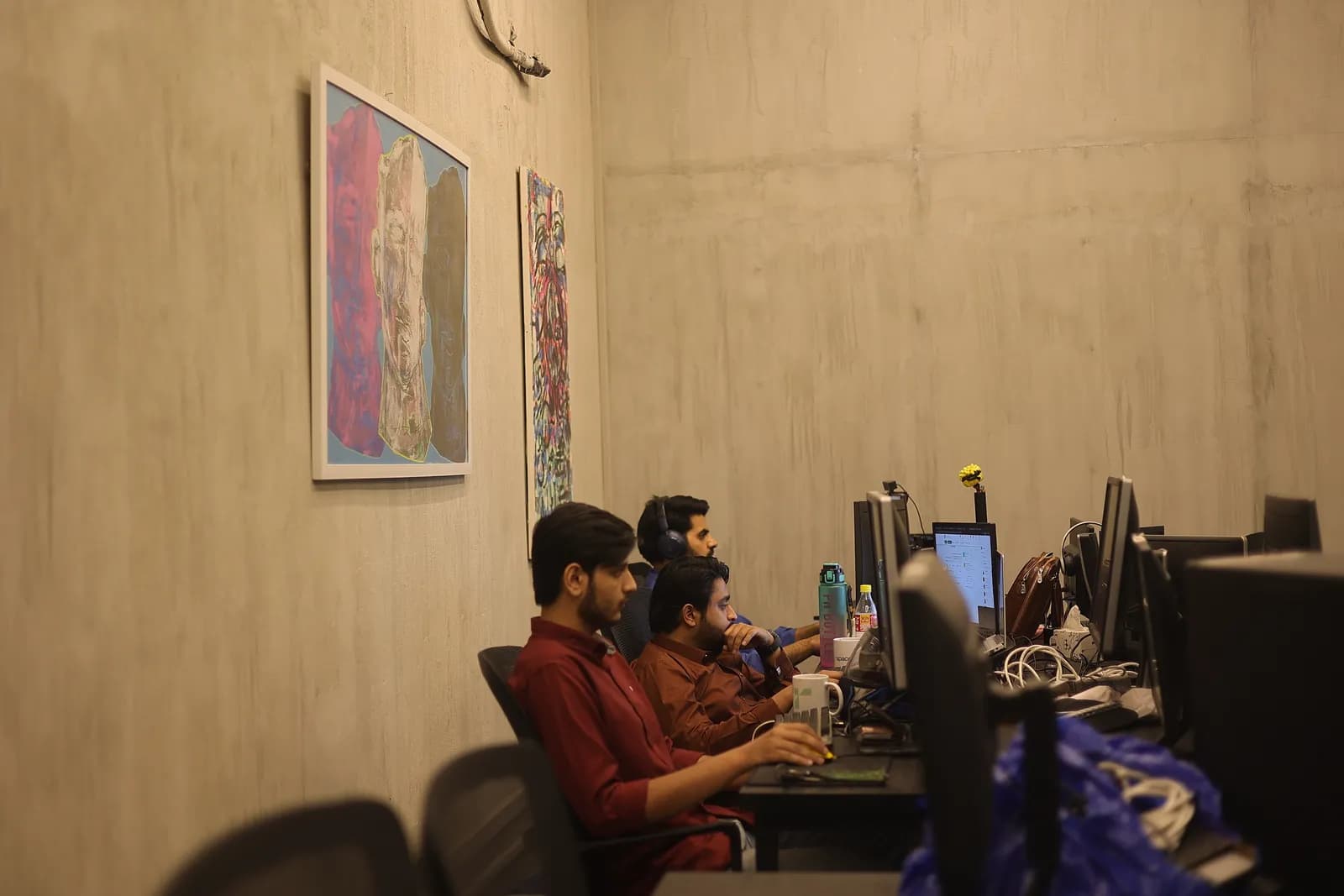 A team working at desks beside artwork on a concrete wall at RSpace Gulmohar Trade Centre