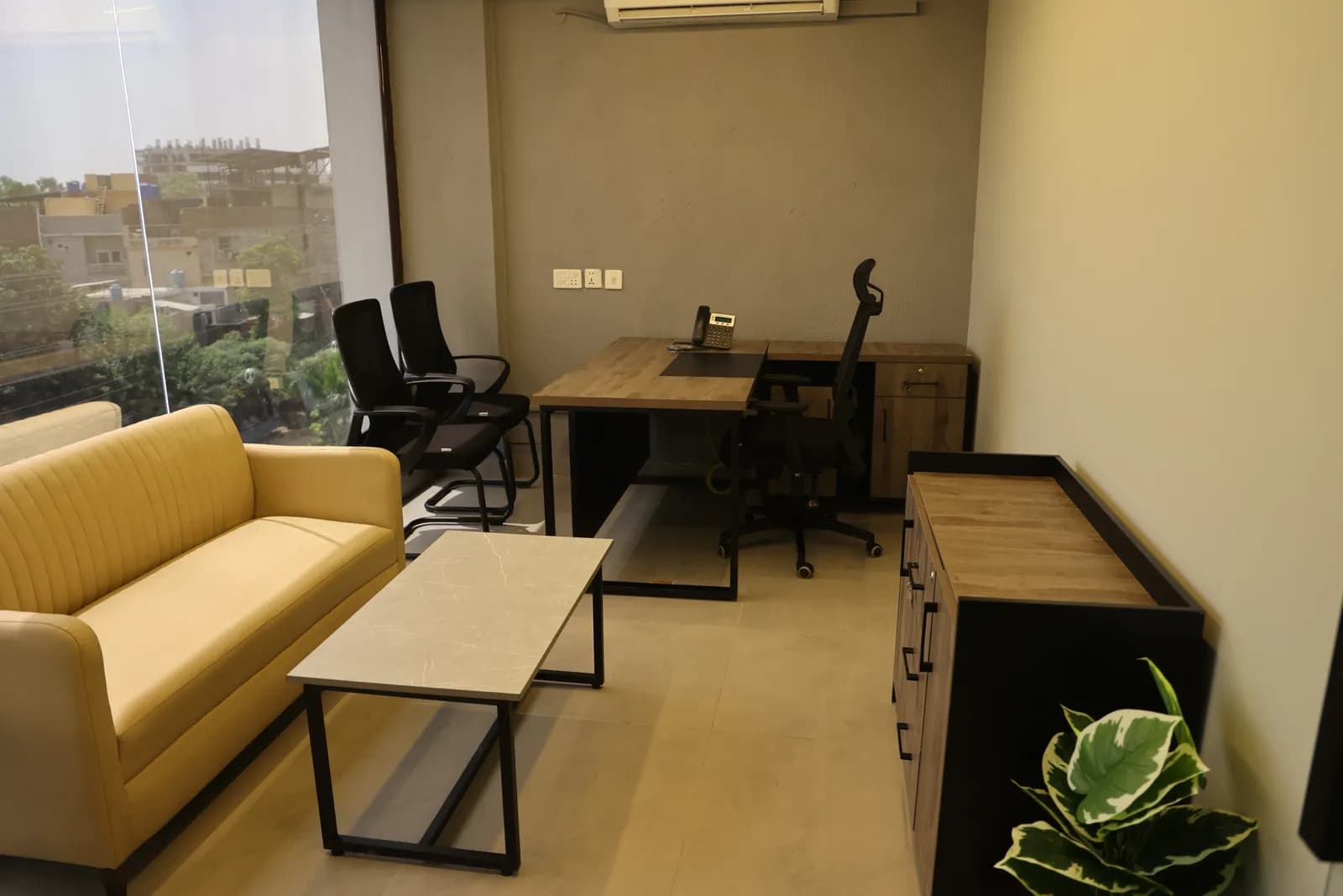 A private office with a sofa, desk and city view at RSpace 59th Street
