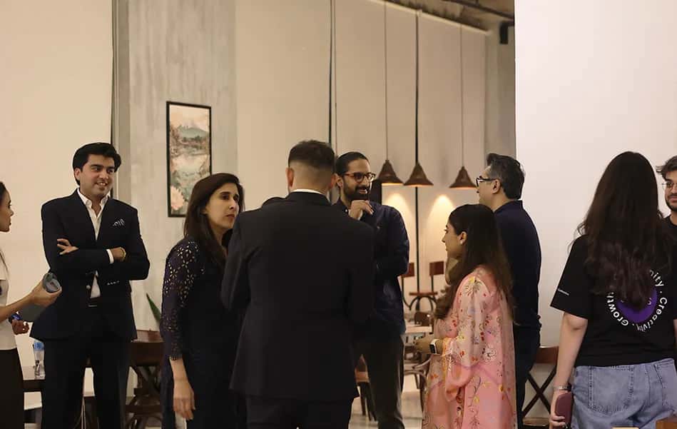 Members and guests talking at an evening gathering in the RSpace lounge, under pendant lights